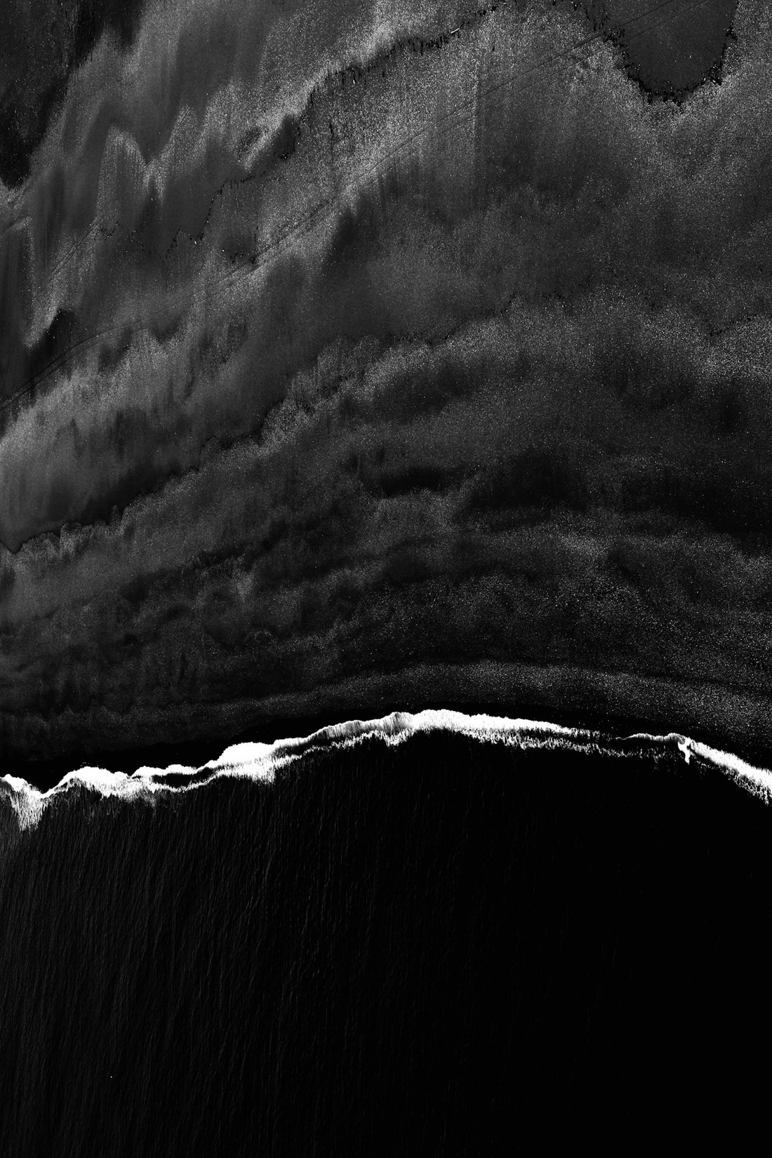 aerial black sand beach with wave
