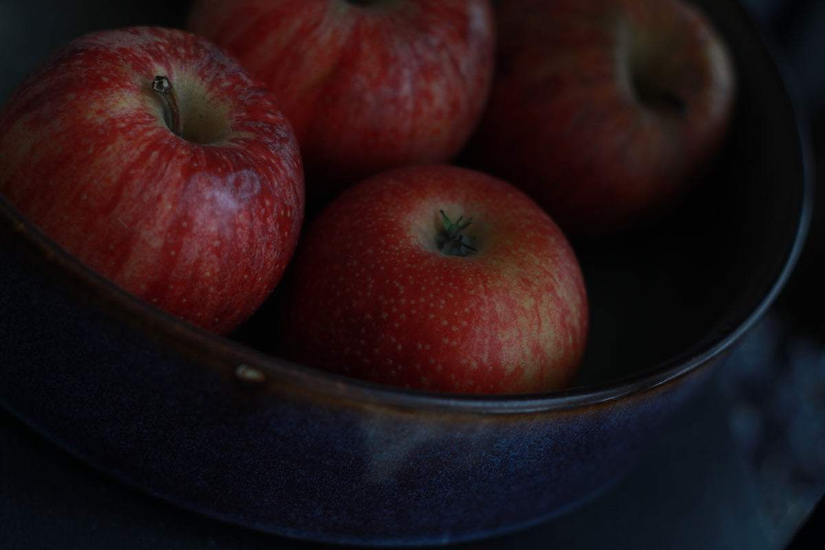 red apples in black ceramic bowl