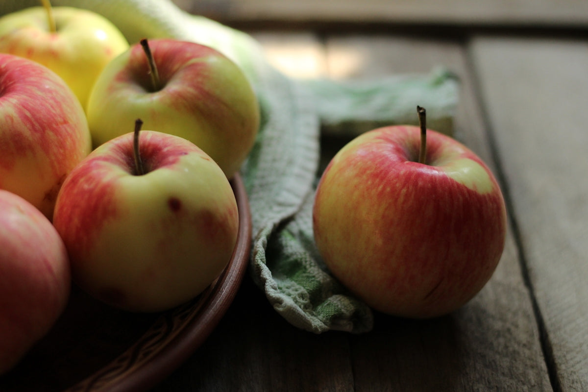 a close up of a bowl of apples on a table