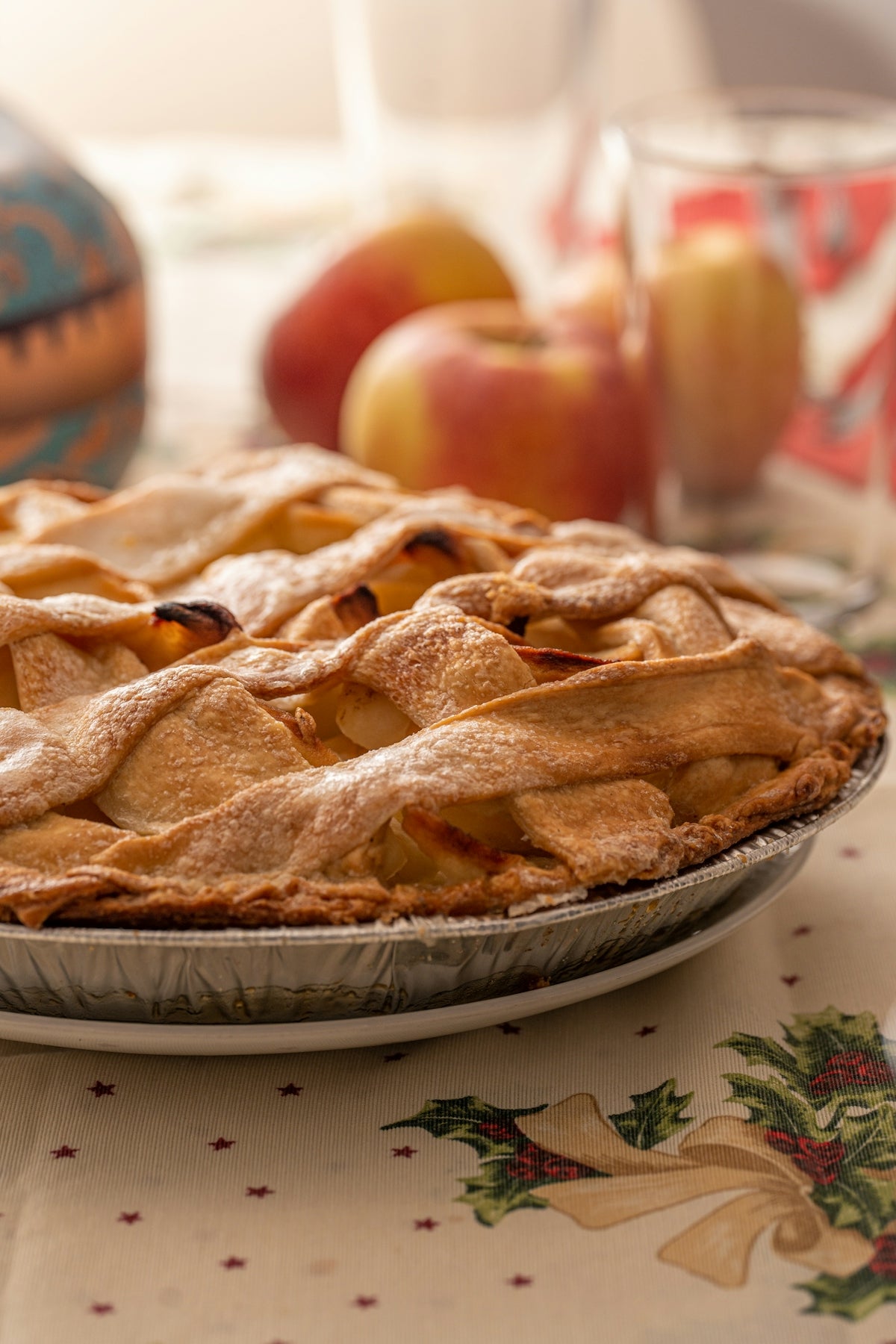 a pie sitting on top of a table next to apples