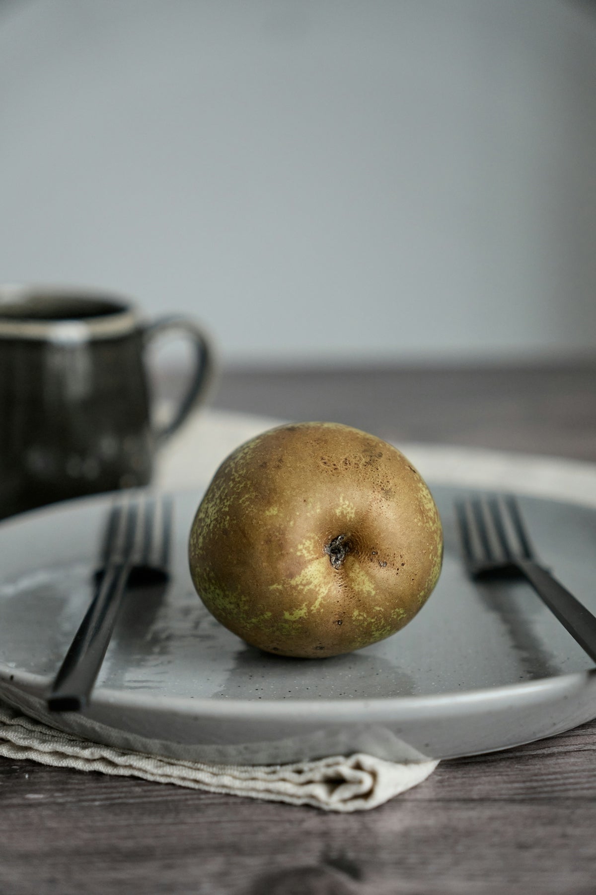 an apple on a plate with a fork and knife