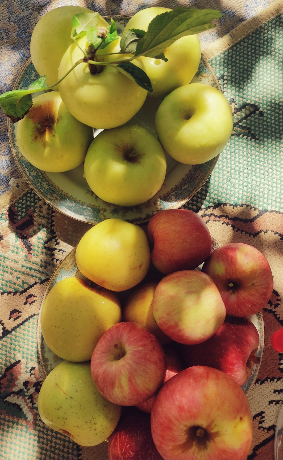 a glass bowl filled with apples on top of a table