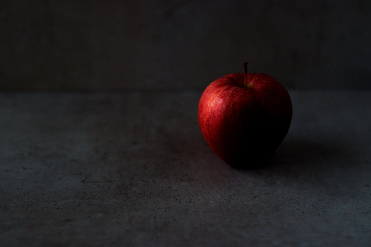 a red apple sitting on top of a table
