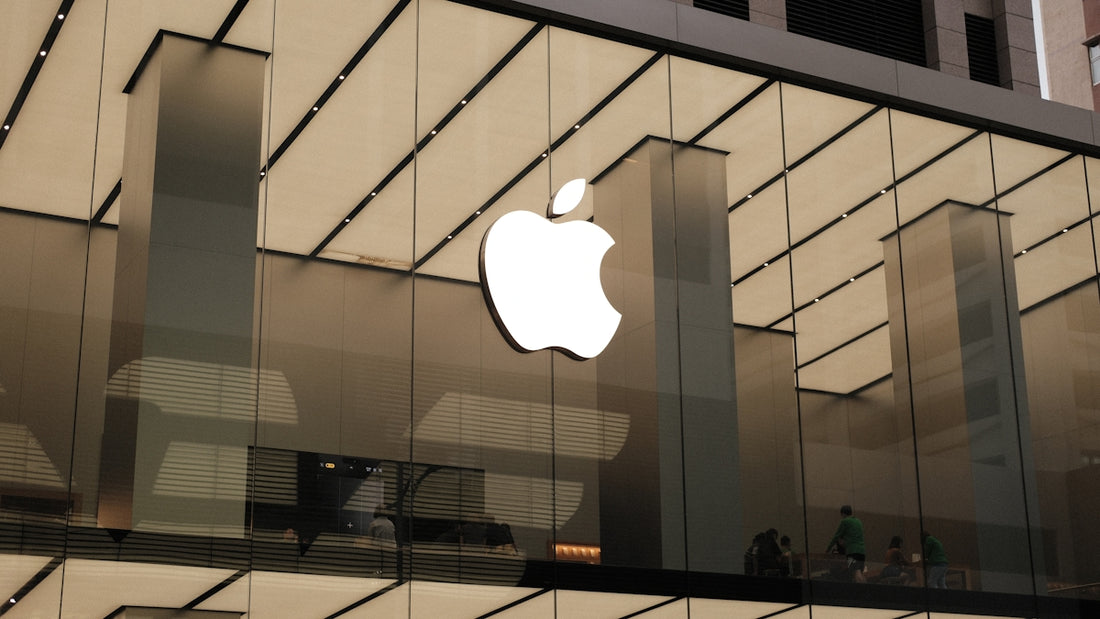 An apple logo is reflected in the glass of a building