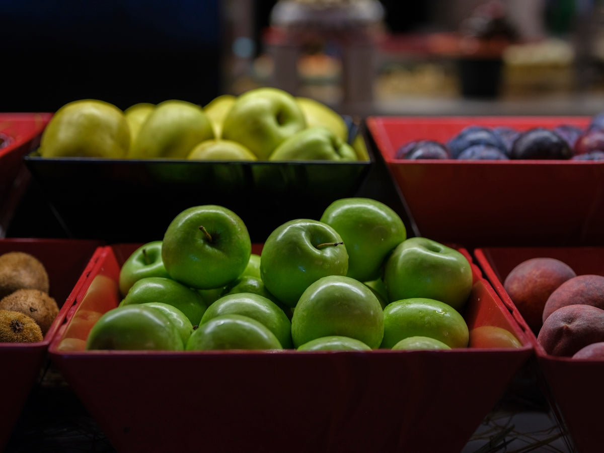 Apples, plums, and potatoes in baskets.