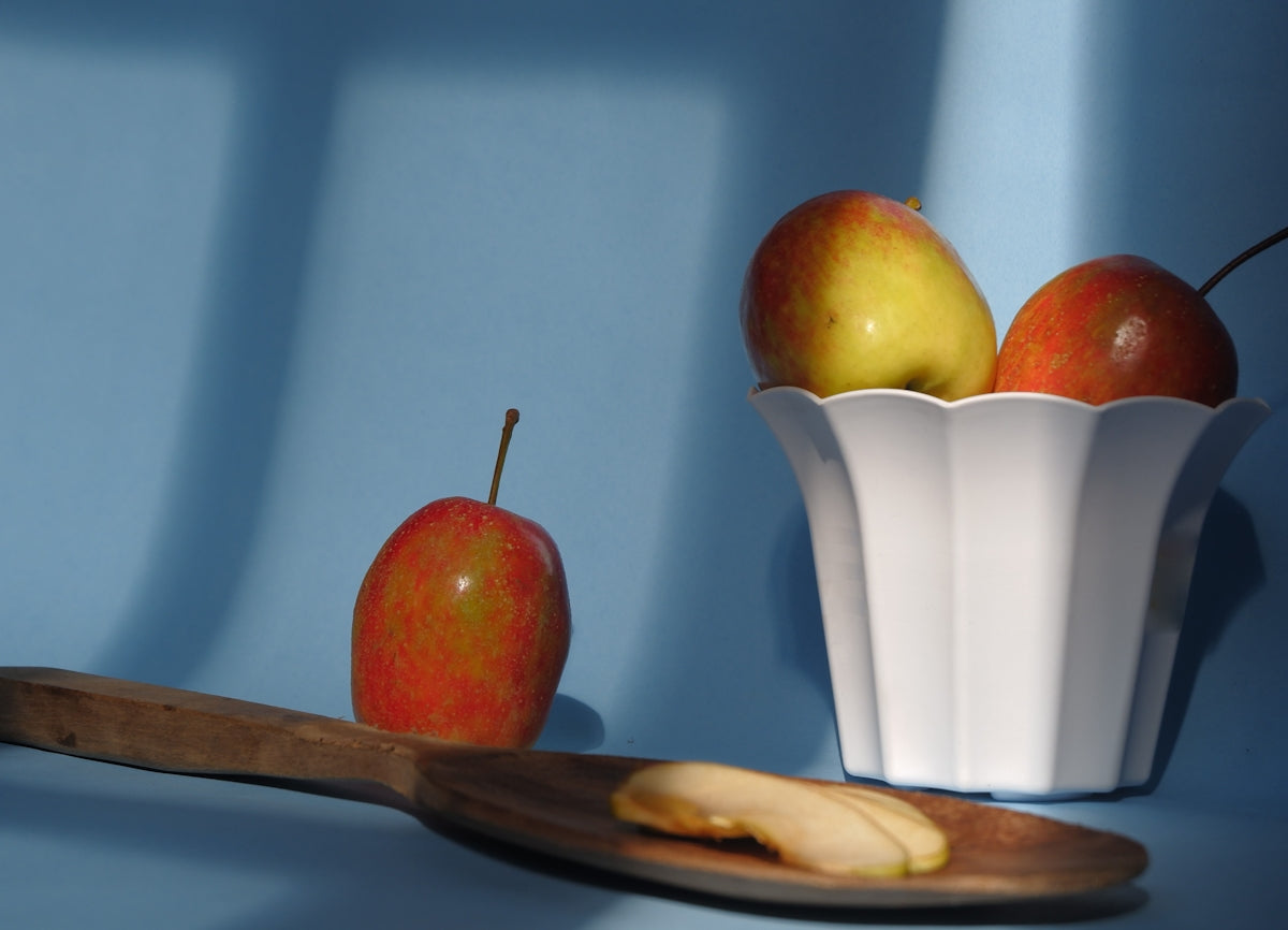Apples and a spoon are on a blue background.